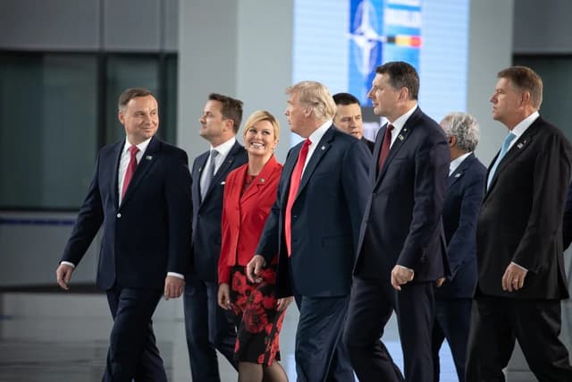 Donald Trump, then-US President, walking alongside other world leaders at a summit.