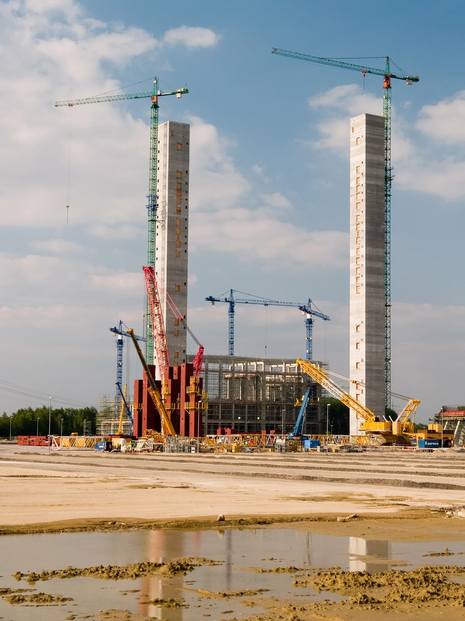 Construction site of a power plant with large concrete structures and cranes.