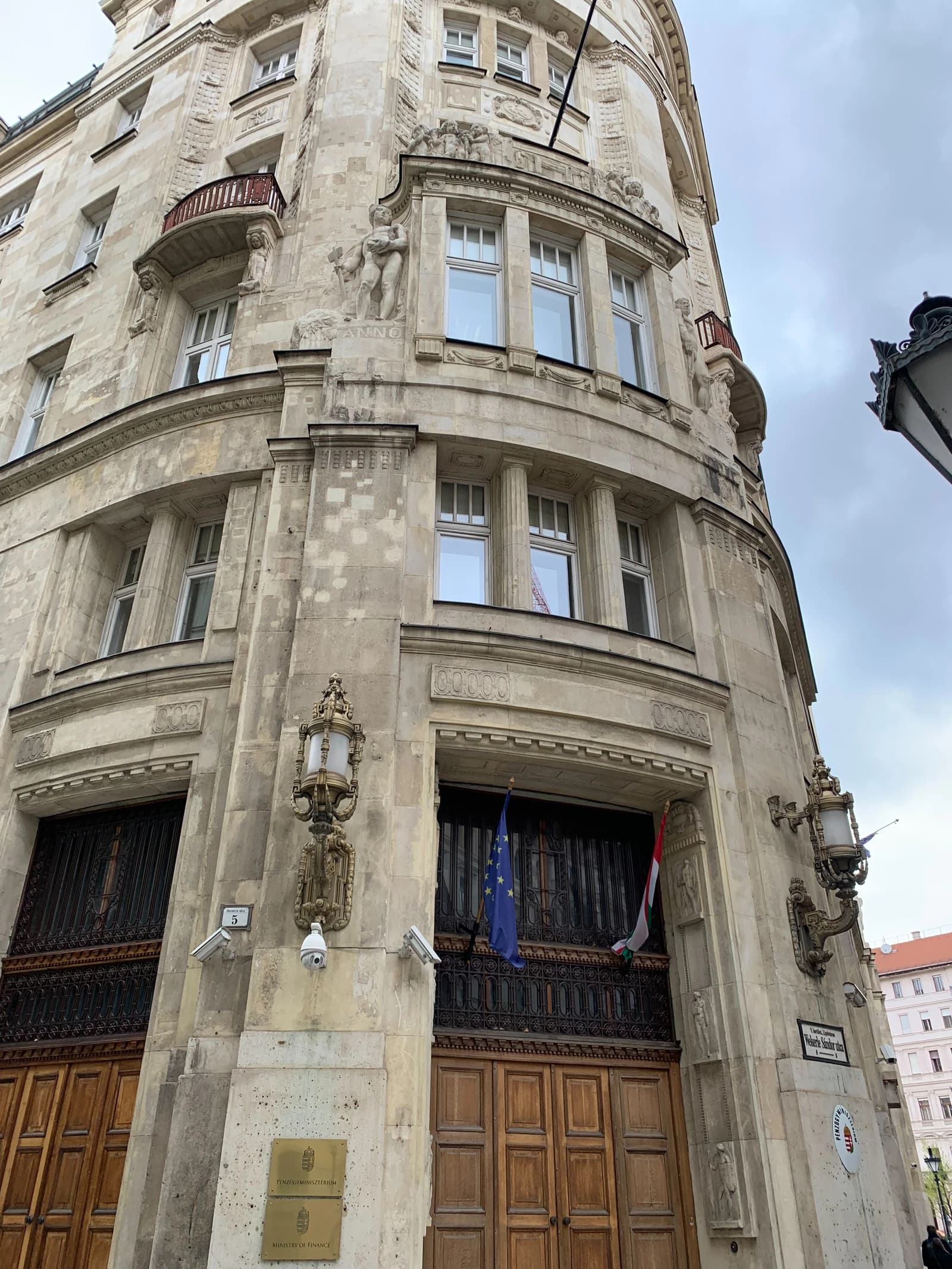 Exterior of the Hungarian Ministry of Finance building in Budapest displaying flags.