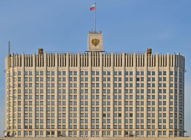 The Russian Government Building facade with a flag and national emblem visible.