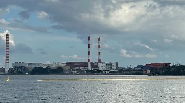 Senoko power station in Singapore, with multiple industrial chimneys visible from across the water.