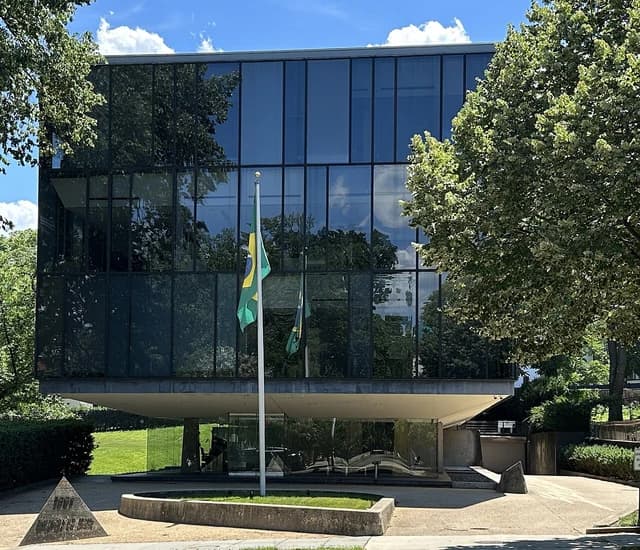Embassy of Brazil, a modern glass building, with the Brazilian flag flying in front.