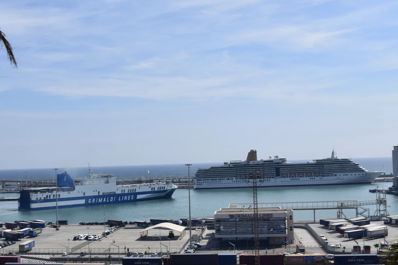 Large white cruise ship MV Arcadia docked in a port with a ferry boat nearby.