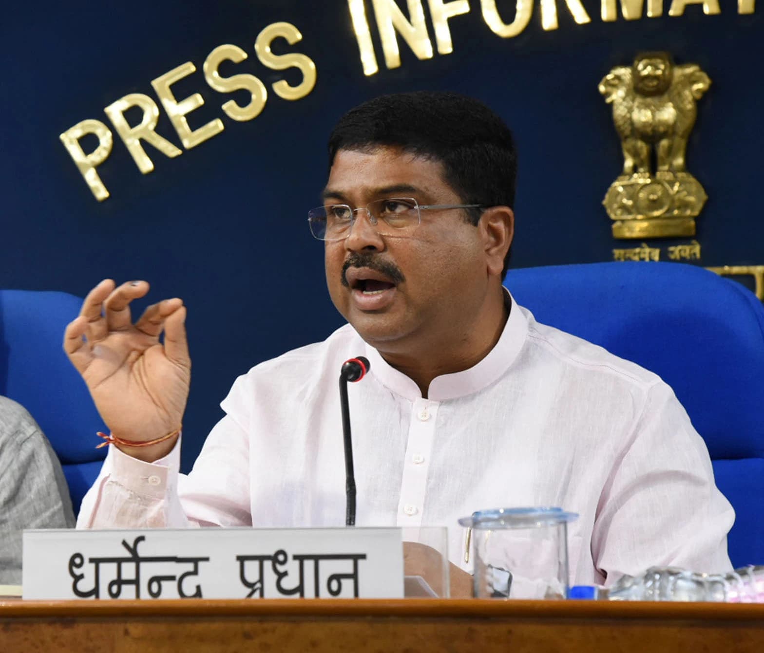 Dharmendra Pradhan addressing a press conference in New Delhi, speaking at microphone.