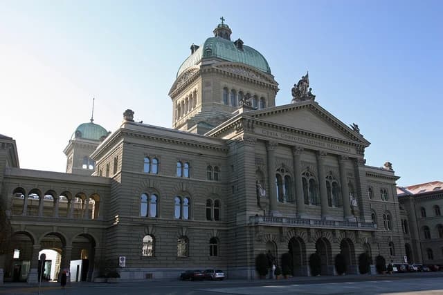 The Federal Palace building, home to the Swiss parliament, under a clear sky.