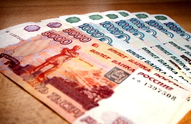 Close-up view of fanned Russian ruble banknotes on a wooden surface.