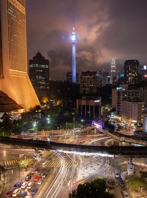 Kuala Lumpur cityscape at night showing the illuminated KL Tower and city lights.