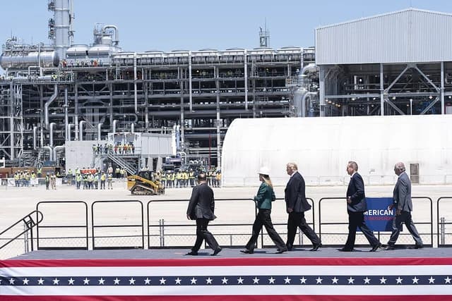 Donald Trump, former U.S. President, walks with a group at an LNG export terminal.