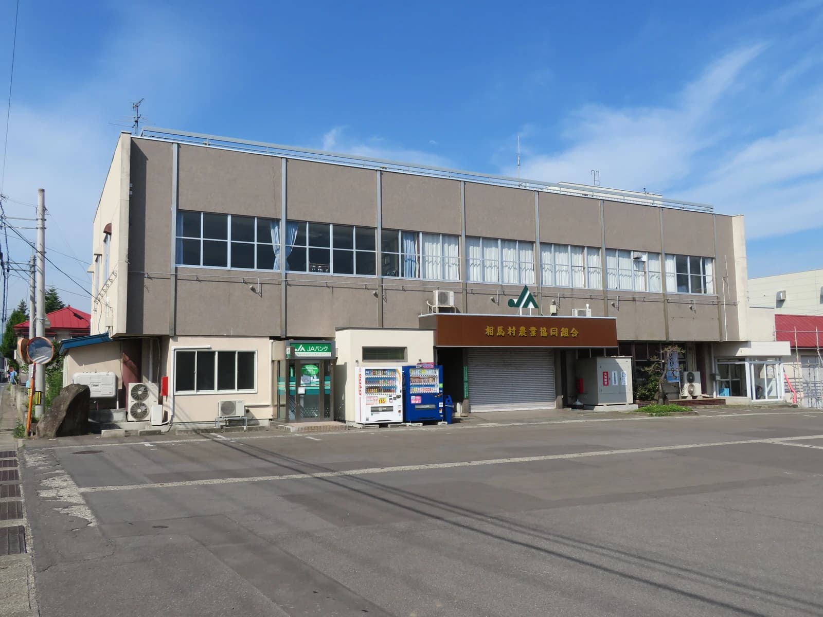 Exterior view of the Soma Village Agricultural Cooperative building under a blue sky.