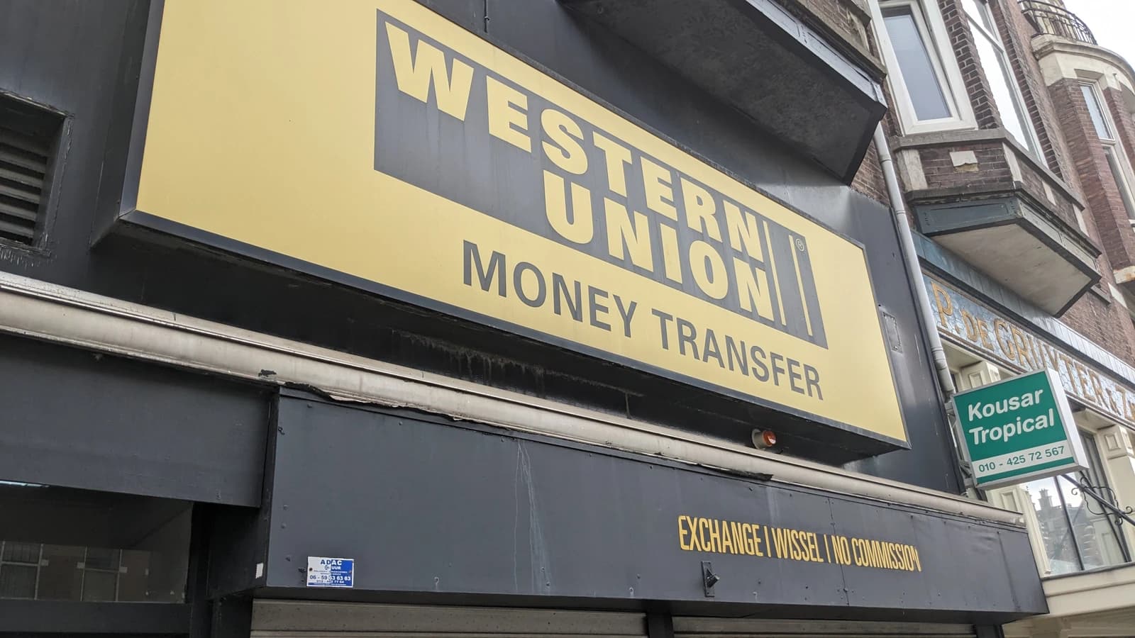 Sign for Western Union money transfer service on a building exterior.