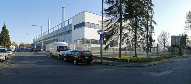 Equinix data center building exterior with street, parked cars, and trees in Frankfurt.