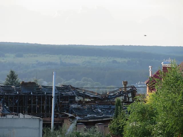 Damaged house in Tsyrkuny, Ukraine, with a collapsed and charred roof.