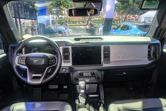 The interior dashboard of a 2026 Ford Bronco Outer Banks, showing the steering wheel and screen.