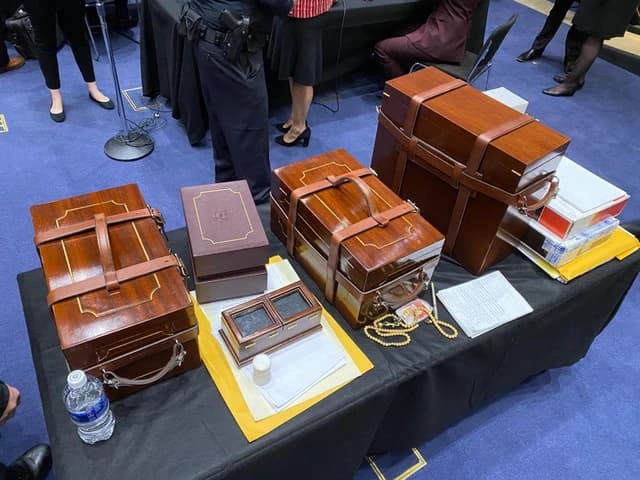 Wooden boxes containing US Electoral College certificates are displayed on a black draped table.
