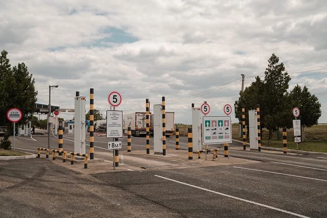 Reni Border Checkpoint with road signs, barriers, and trucks visible in the background.