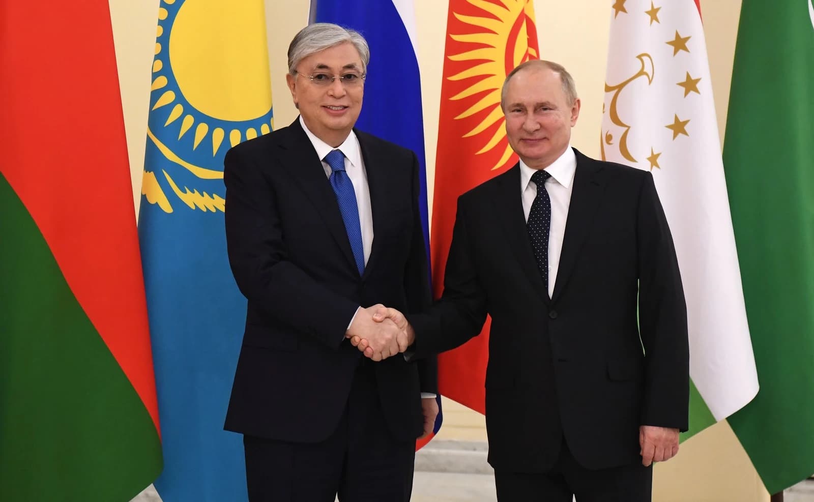 Kassym-Jomart Tokayev, President of Kazakhstan, and Vladimir Putin, President of Russia, shake hands.