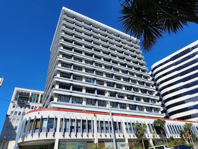 Exterior view of the Reserve Bank of New Zealand building in Wellington against a blue sky.