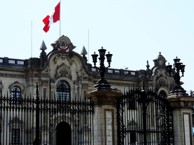 Peruvian flag flying above the historic Government Palace in Lima, Peru.