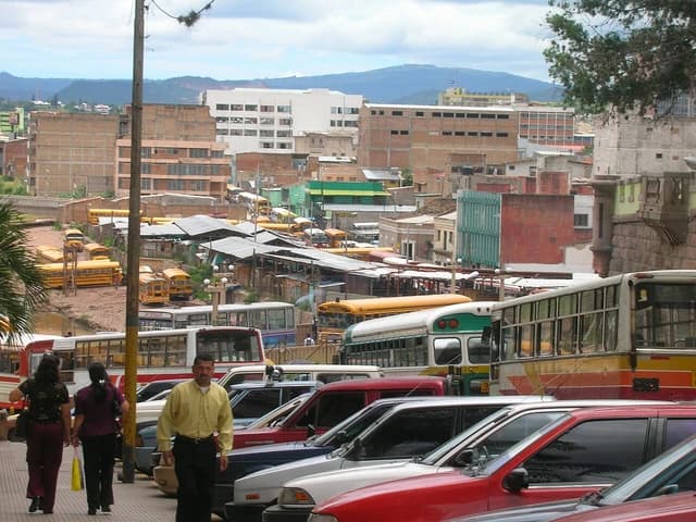 Buses and cars parked on a street in Tegucigalpa, Honduras.