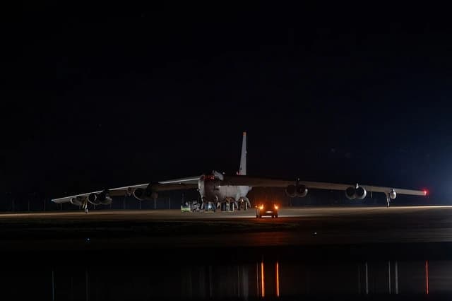 B-52 Stratofortress bomber aircraft on a tarmac at RAF Fairford at night.