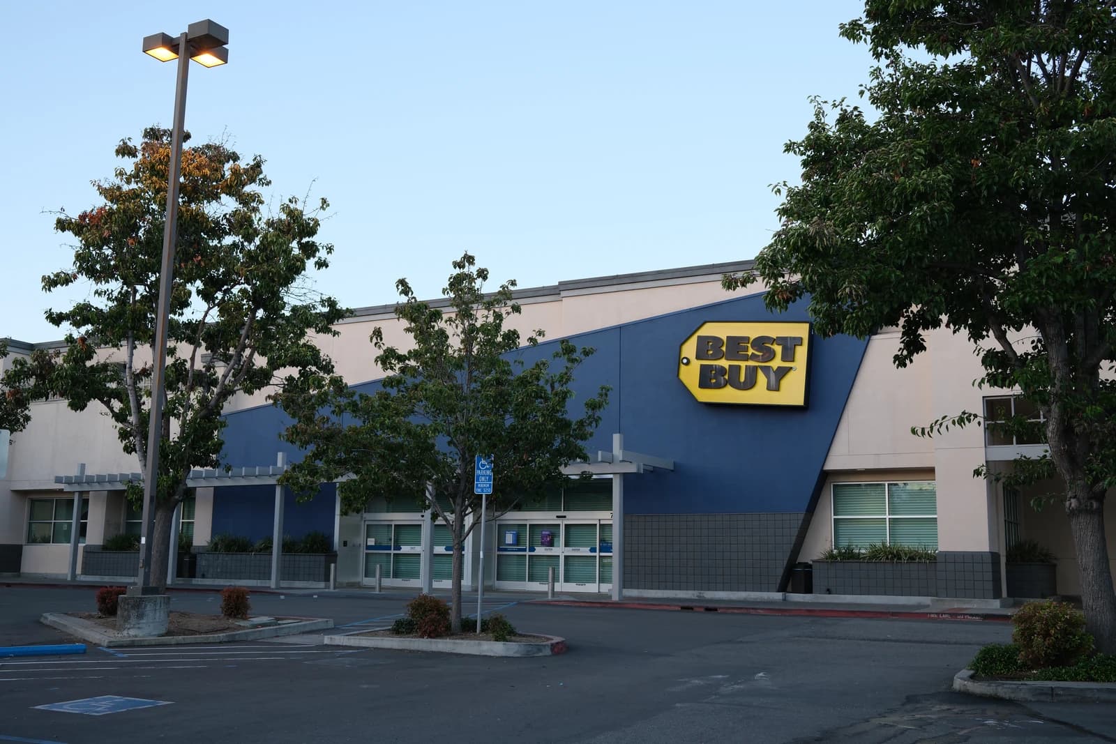 Exterior view of a Best Buy electronics store building with its distinctive yellow logo.