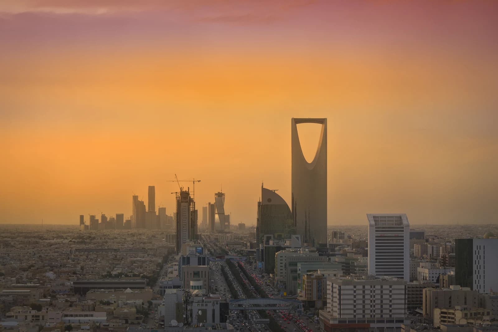 Riyadh skyline, King Abdullah Financial District, and Kingdom Tower at sunset.