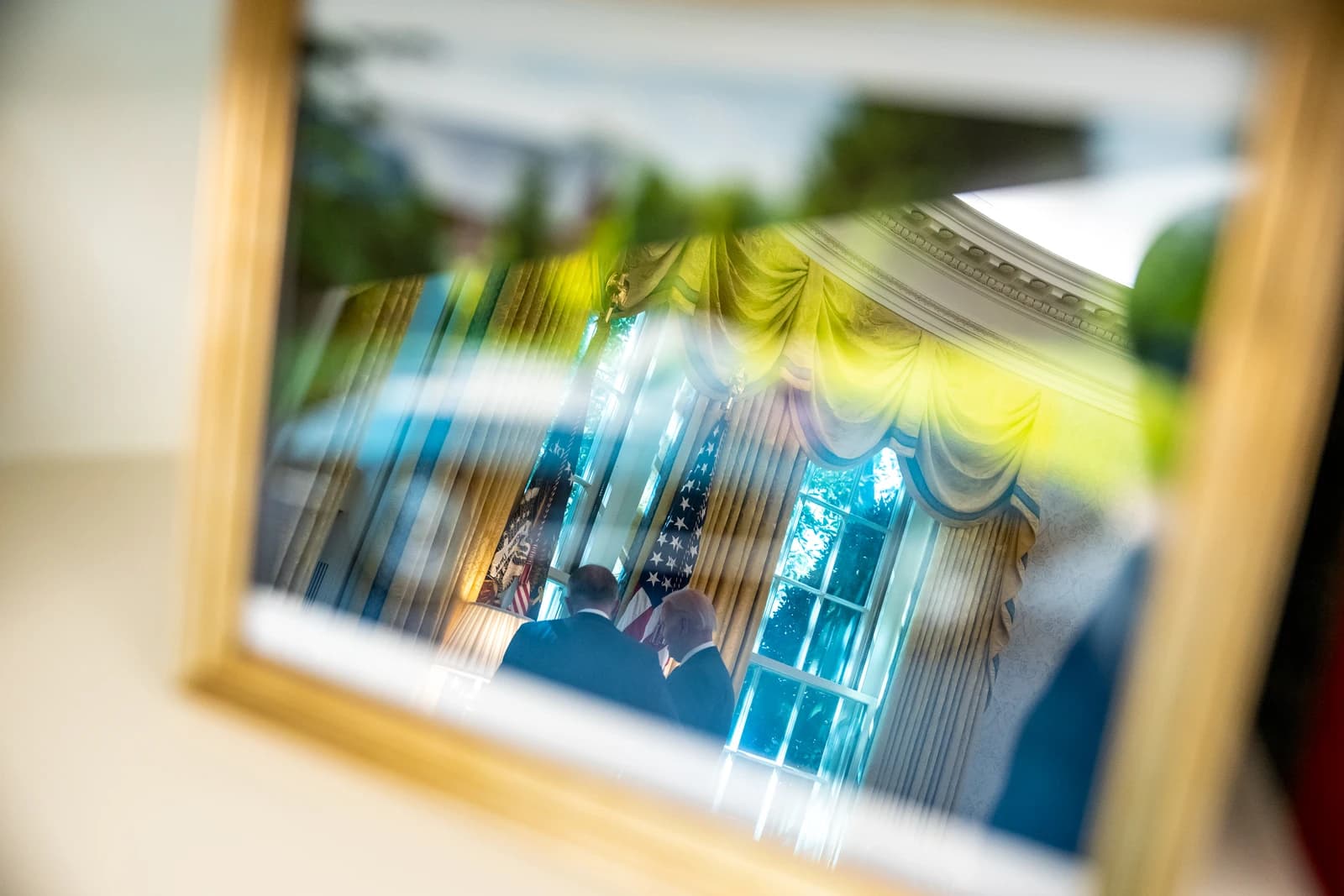 President Joe Biden and Prime Minister Anthony Albanese reflected in a framed picture in the Oval Office.