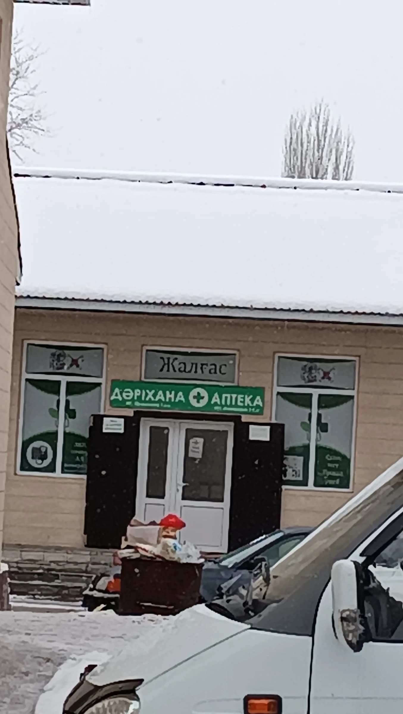 Exterior of the "Zhalgas" pharmacy in Kuln, Kazakhstan, under snow.