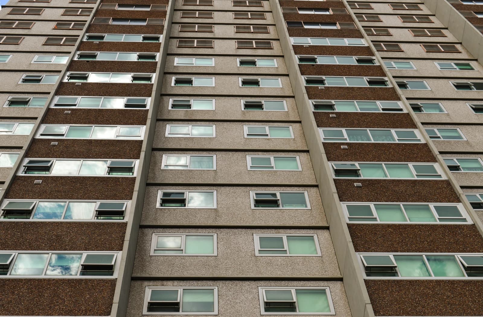 Close-up of a residential building's facade with multiple rows of windows.