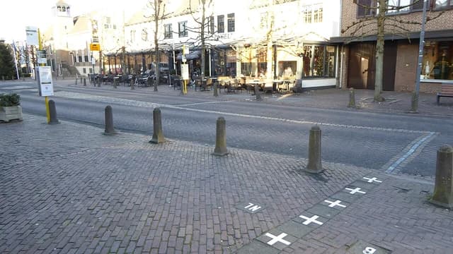 Street scene in Baarle with border markings on the pavement and a building facade.