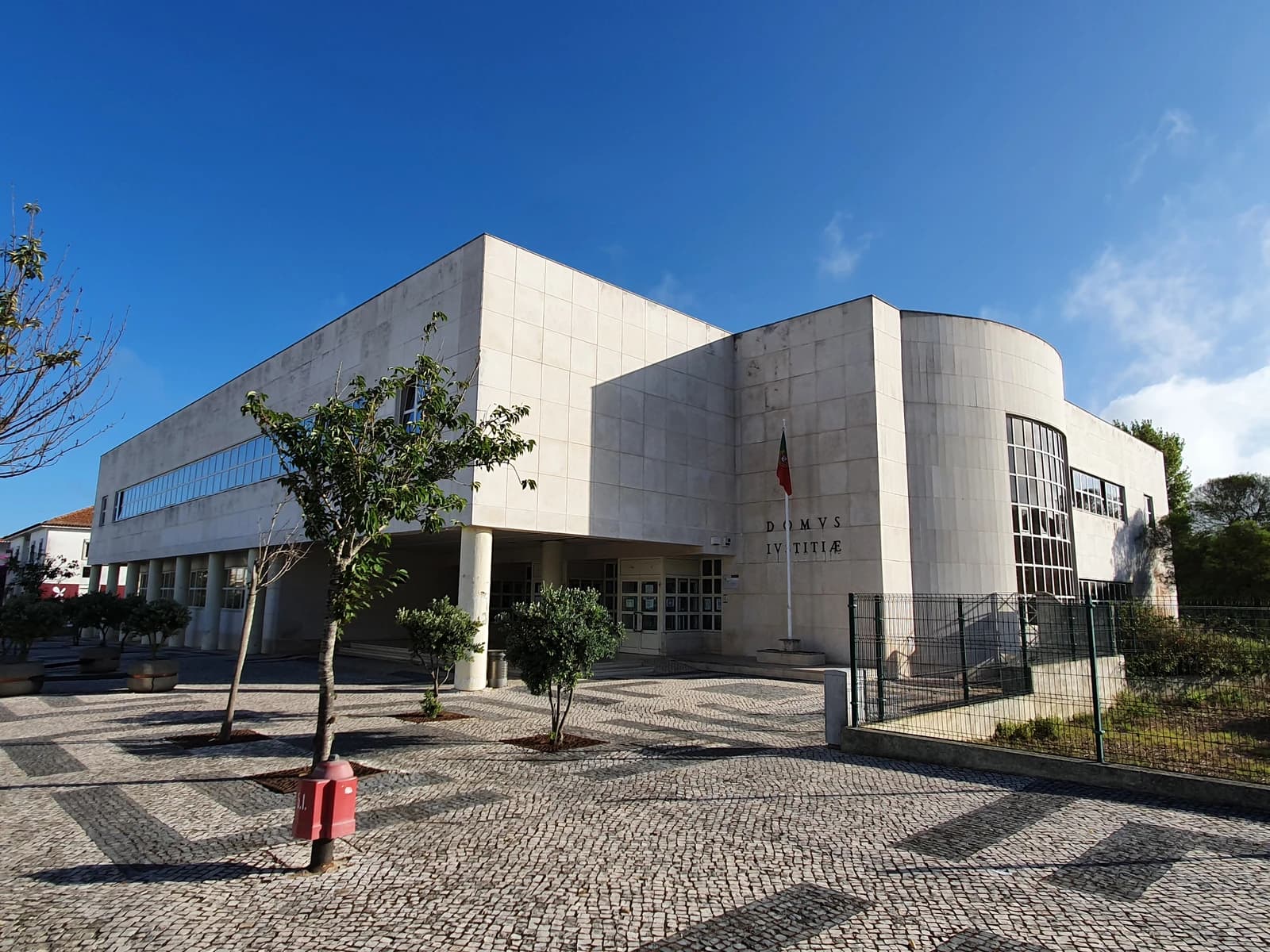 Exterior of the Mafra Palace of Justice building in Portugal, with a clear blue sky.