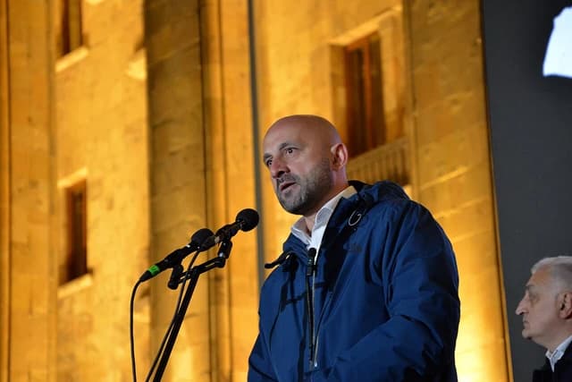 Levan Tsutskiridze, a politician, speaking at a rally with microphones.