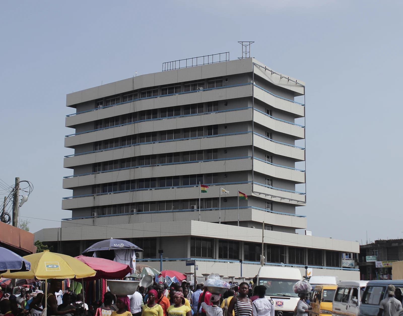 Ghana Commercial Bank building in Accra, Ghana, with people and market stalls.
