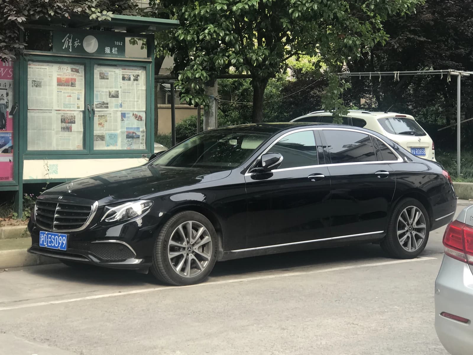 A black Mercedes-Benz E-Class sedan parked on a street in an urban setting.