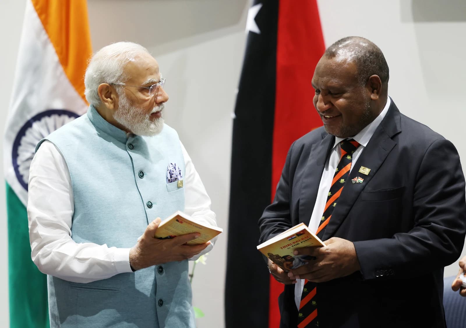 Prime Minister Narendra Modi and Prime Minister James Marape holding books in Port Moresby.