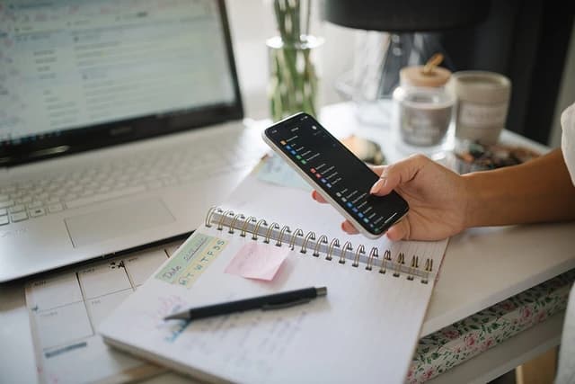 Young businesswoman holding her smartphone in her home office.