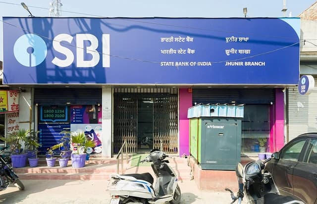 Exterior of a State Bank of India branch with large blue sign and closed metal gate.