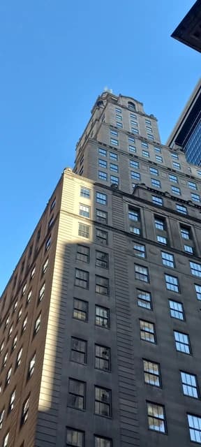 Skyscraper in Manhattan's Financial District with sunlight on one side.