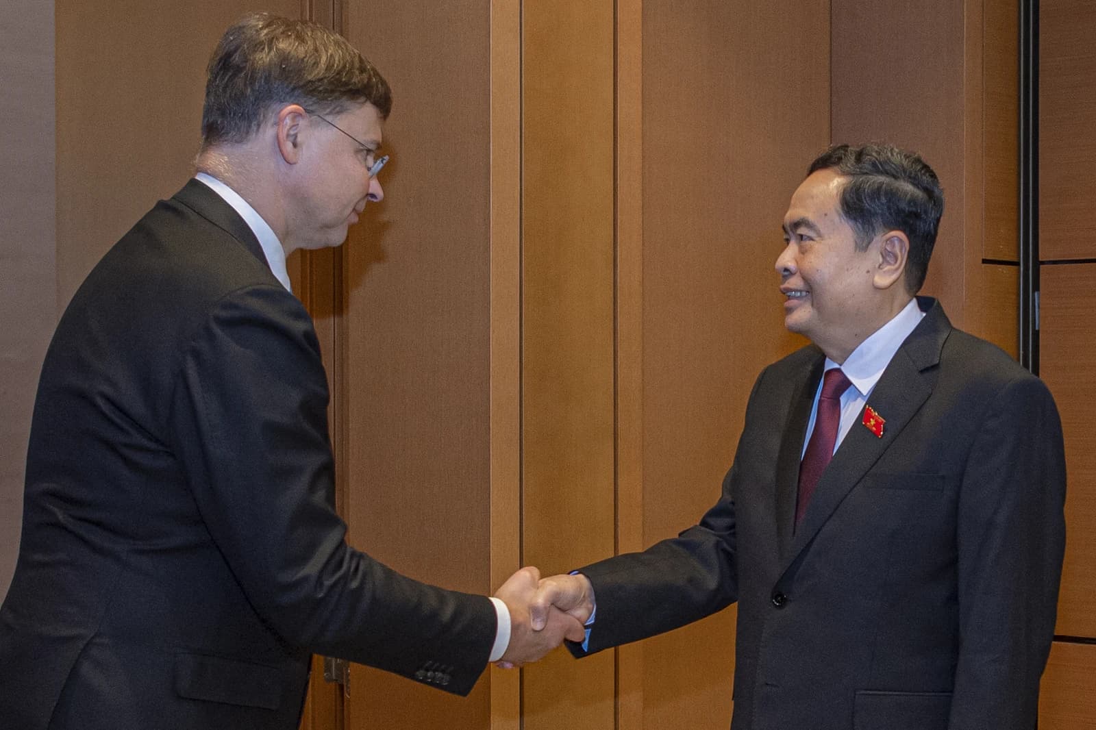 Valdis Dombrovskis and Tran Thanh Man shaking hands indoors.