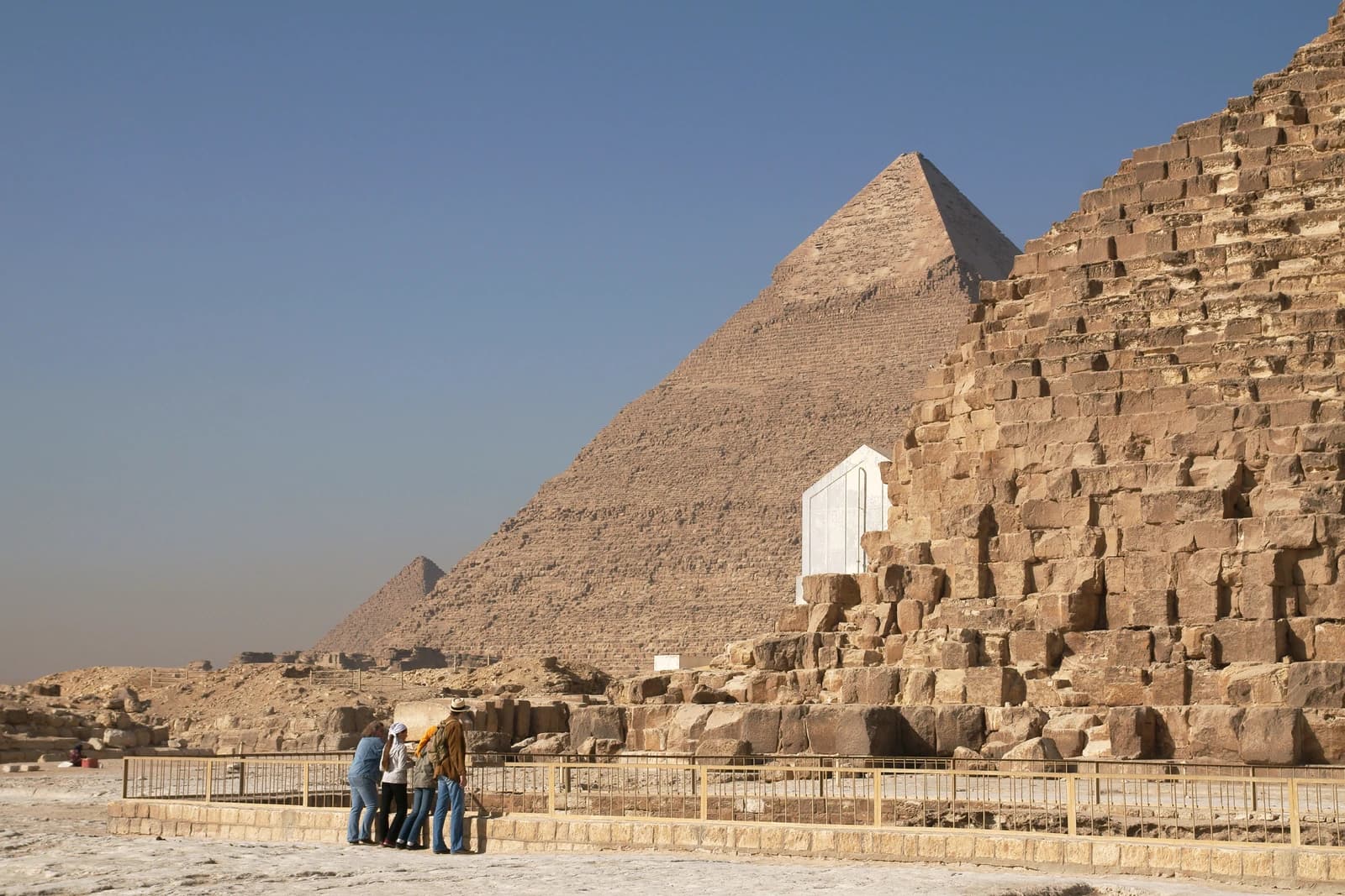 Group of tourists standing near the Great Pyramids of Giza, Egypt.