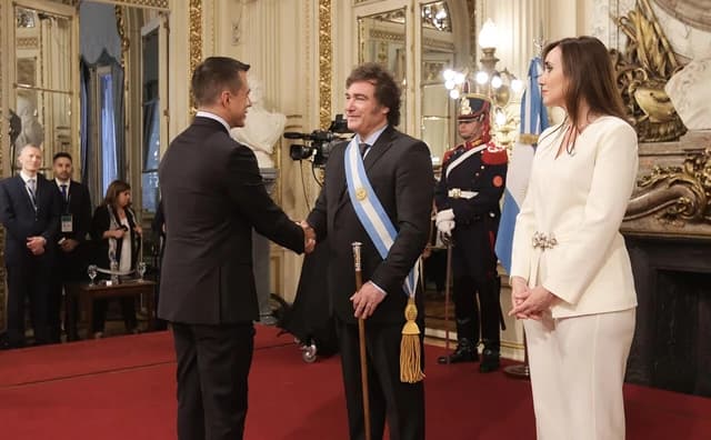 Javier Milei, President of Argentina, shakes hands with a man at his inauguration.