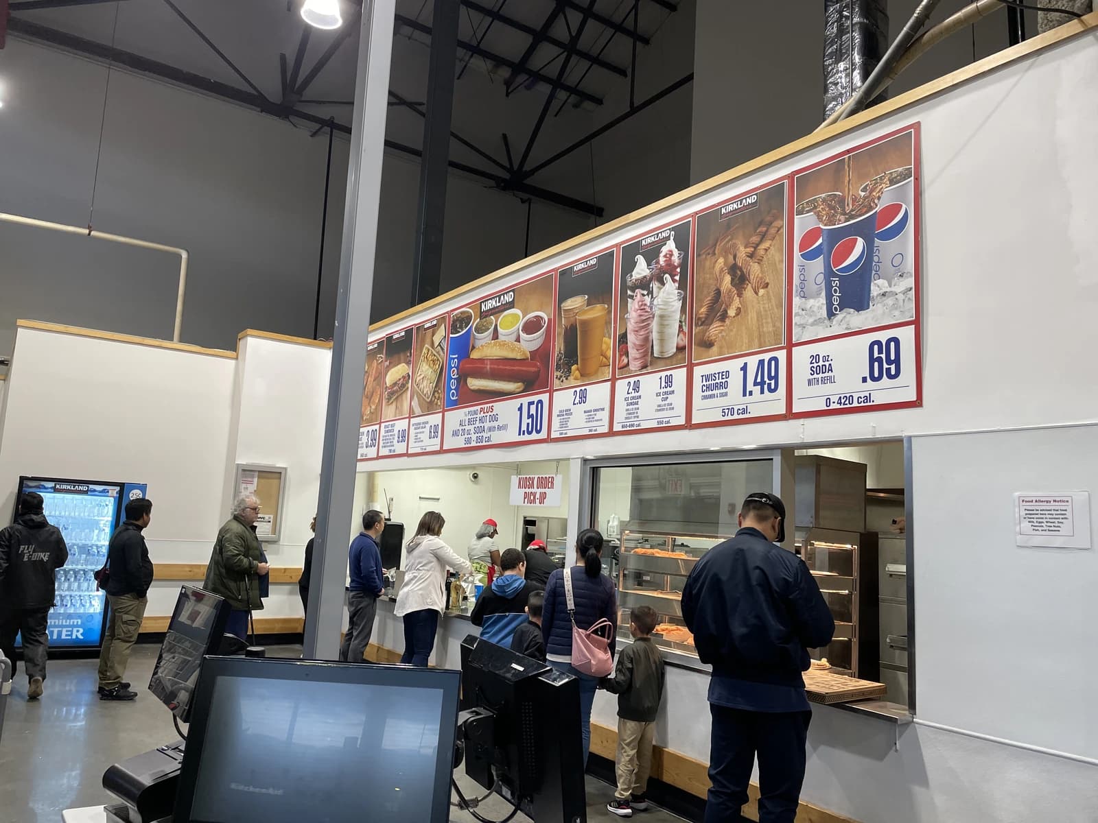 People queuing at the food court counter inside a Costco Wholesale warehouse in Queens, New York.