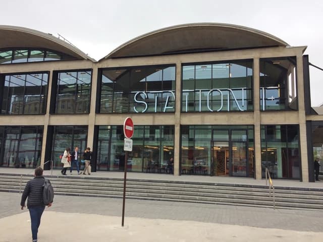 Exterior view of Station F building with large glass windows and concrete facade.