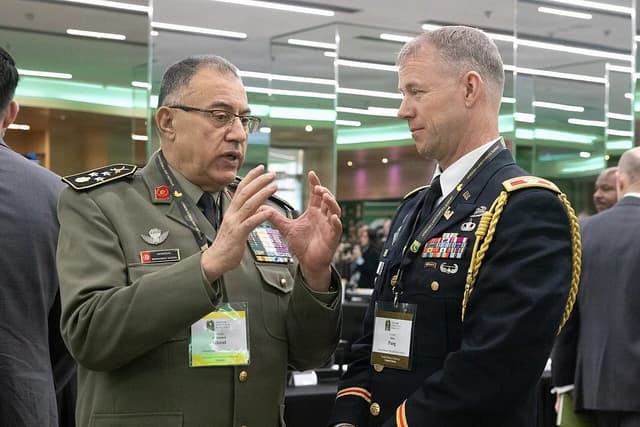 General Mohamed Ghoul speaks with Colonel Philip Pang at a summit event.