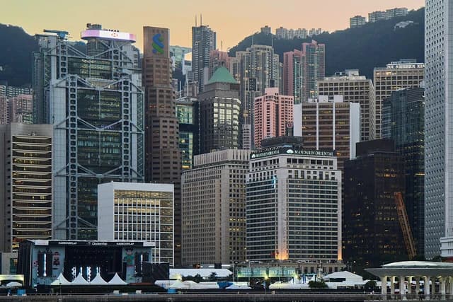 Hong Kong skyline showing multiple high-rise buildings and waterfront structures.