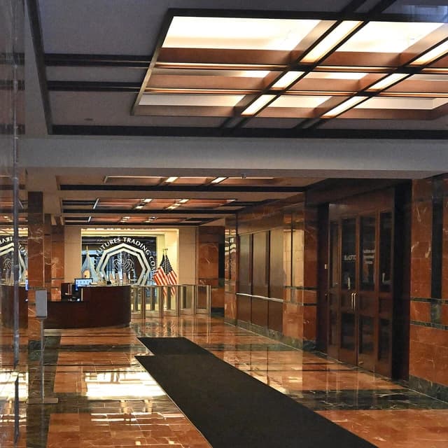 Interior of the CFTC lobby featuring reception desk, glass doors, and an American flag.