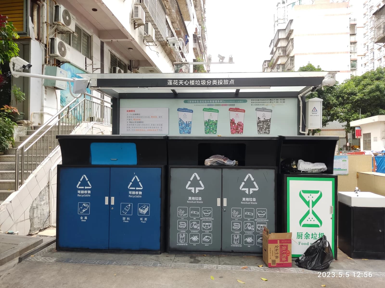 Recycle boxes for metal, plastic, paper, and food waste on a street in Shenzhen.