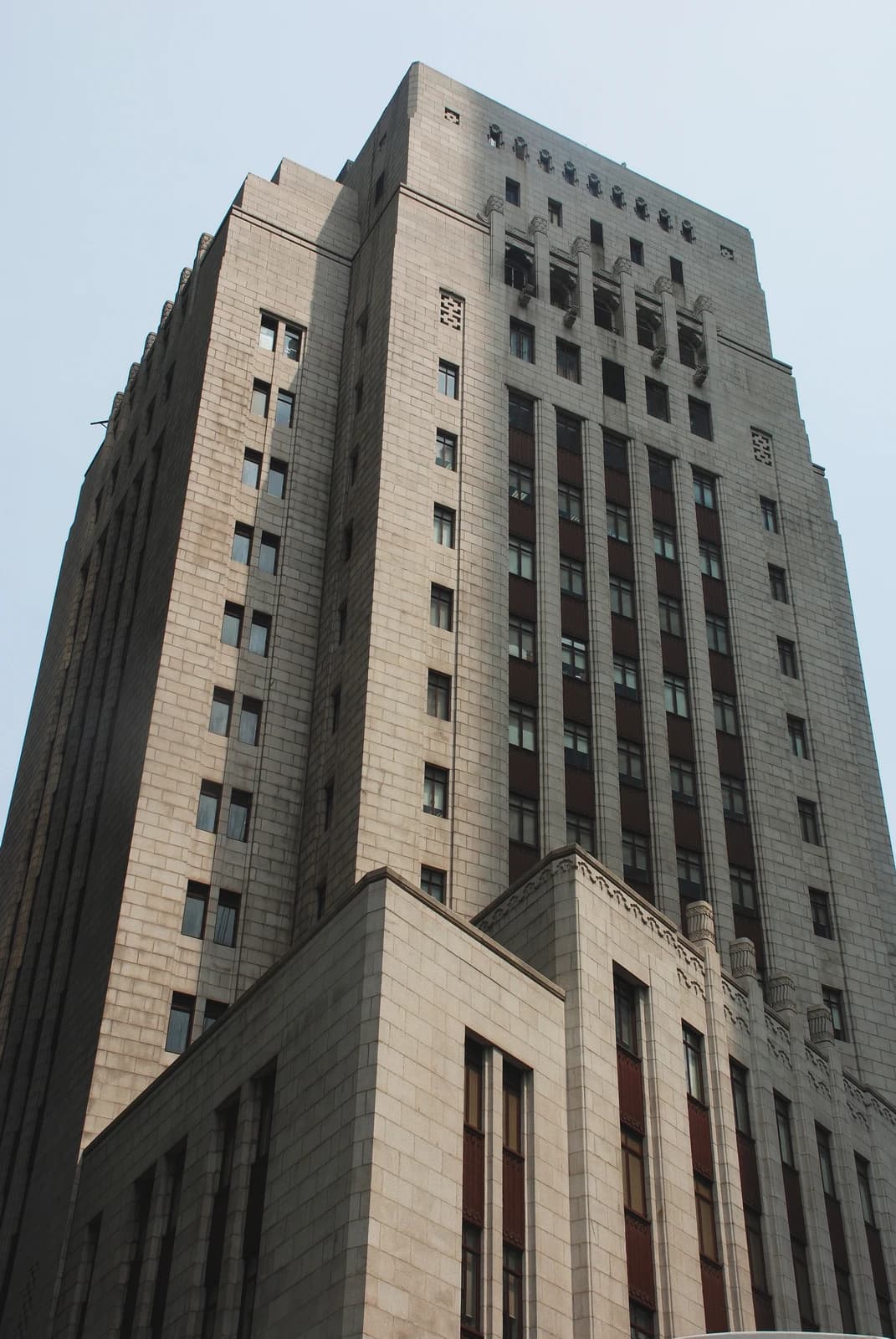 Bank of China Building exterior, a tall stone skyscraper with many windows.