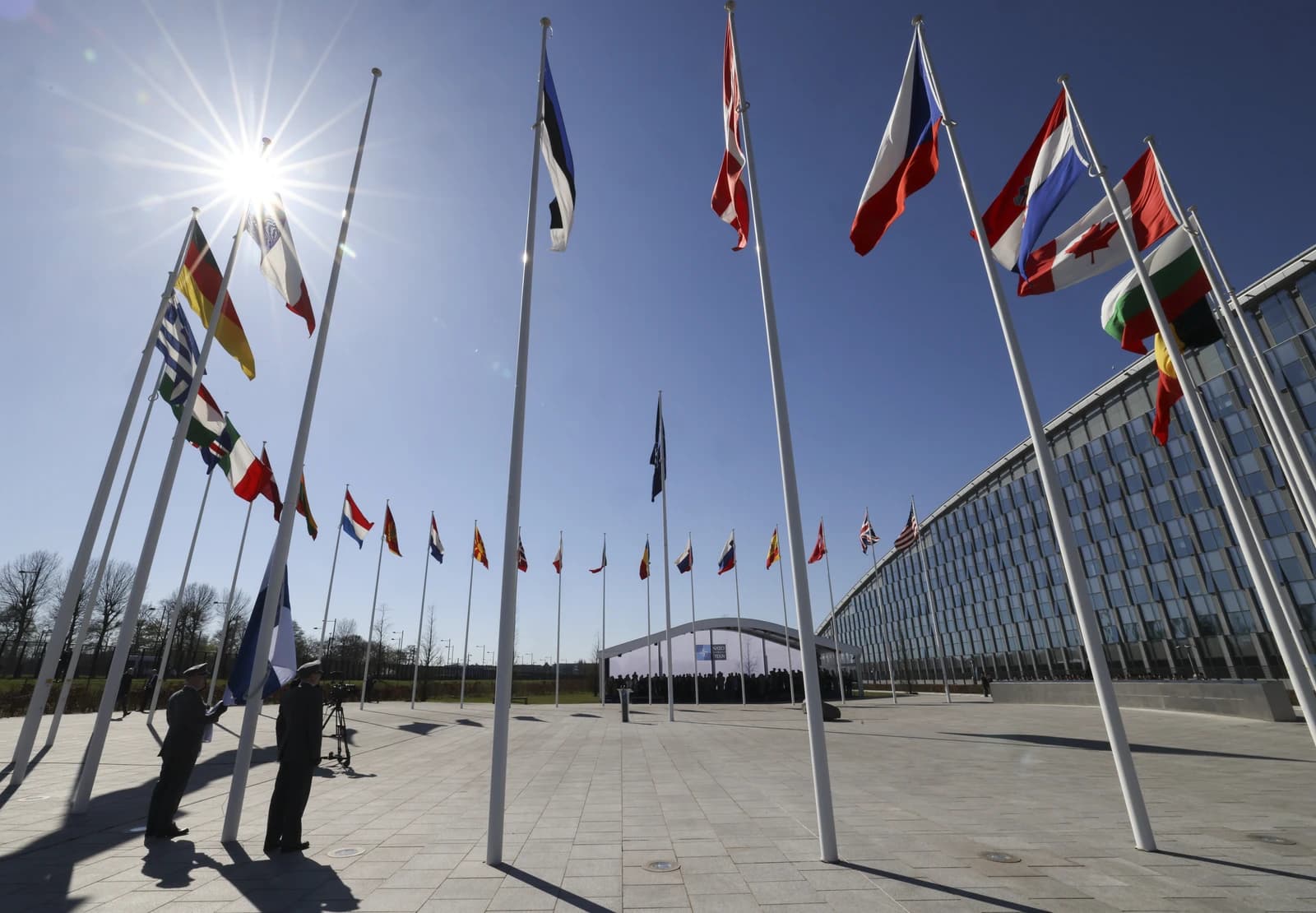 NATO member state flags flying outside the NATO Headquarters building in Brussels.