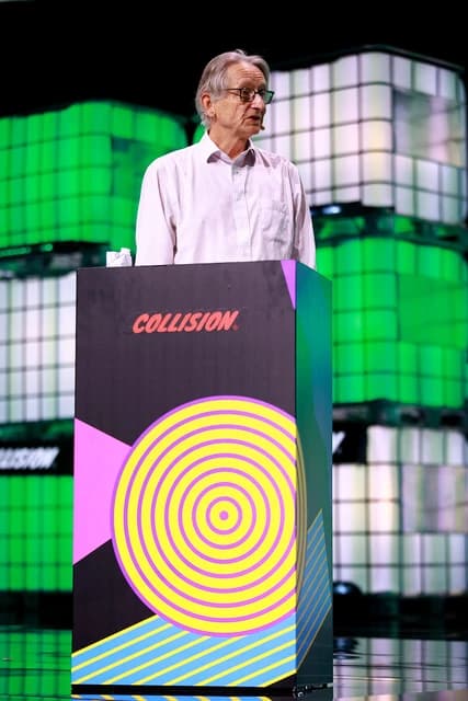 Geoffrey Hinton, artificial intelligence researcher, speaking at a podium during a conference.